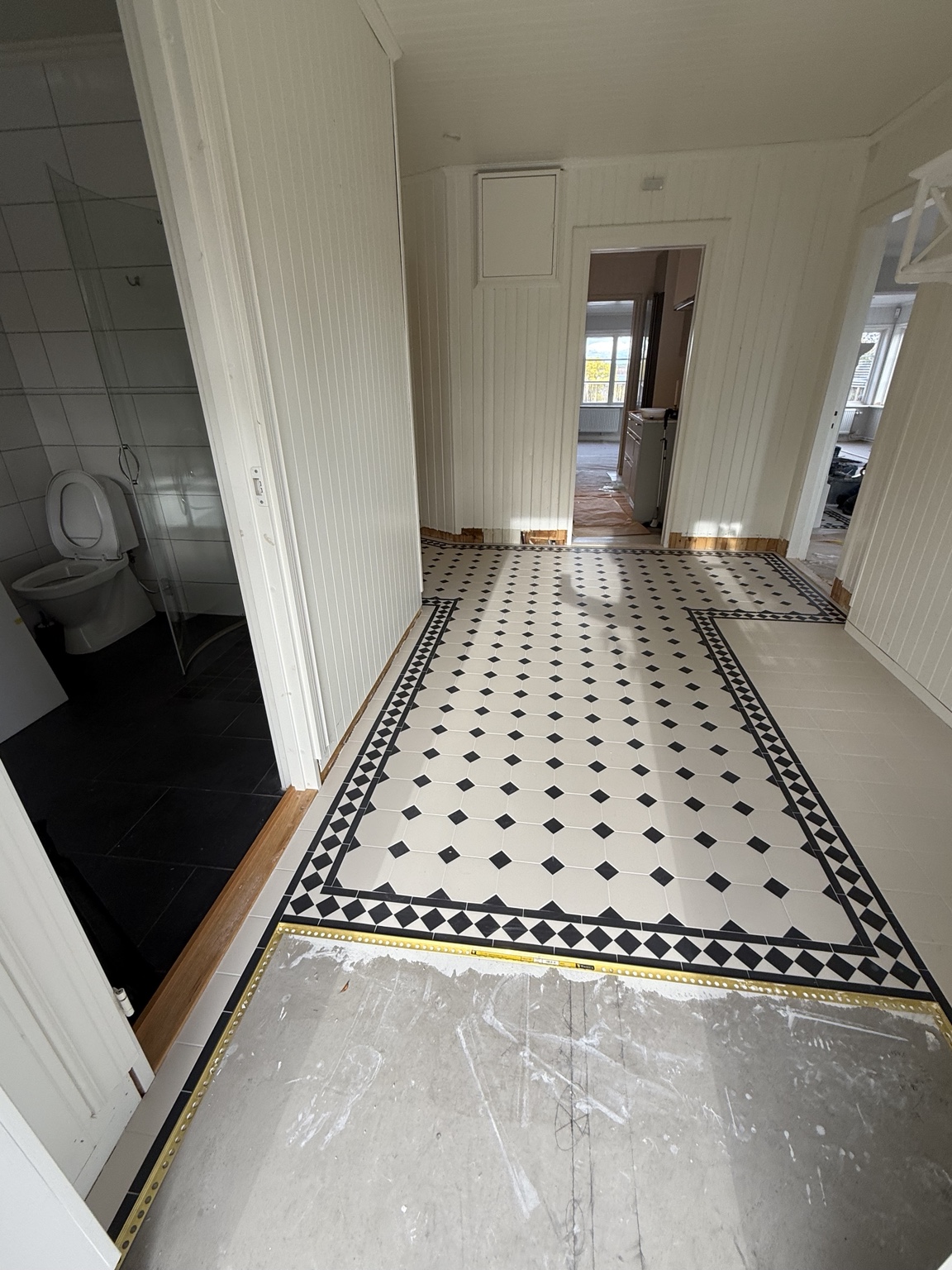 Mönsterlagt golv i hall under arbete på Resarö