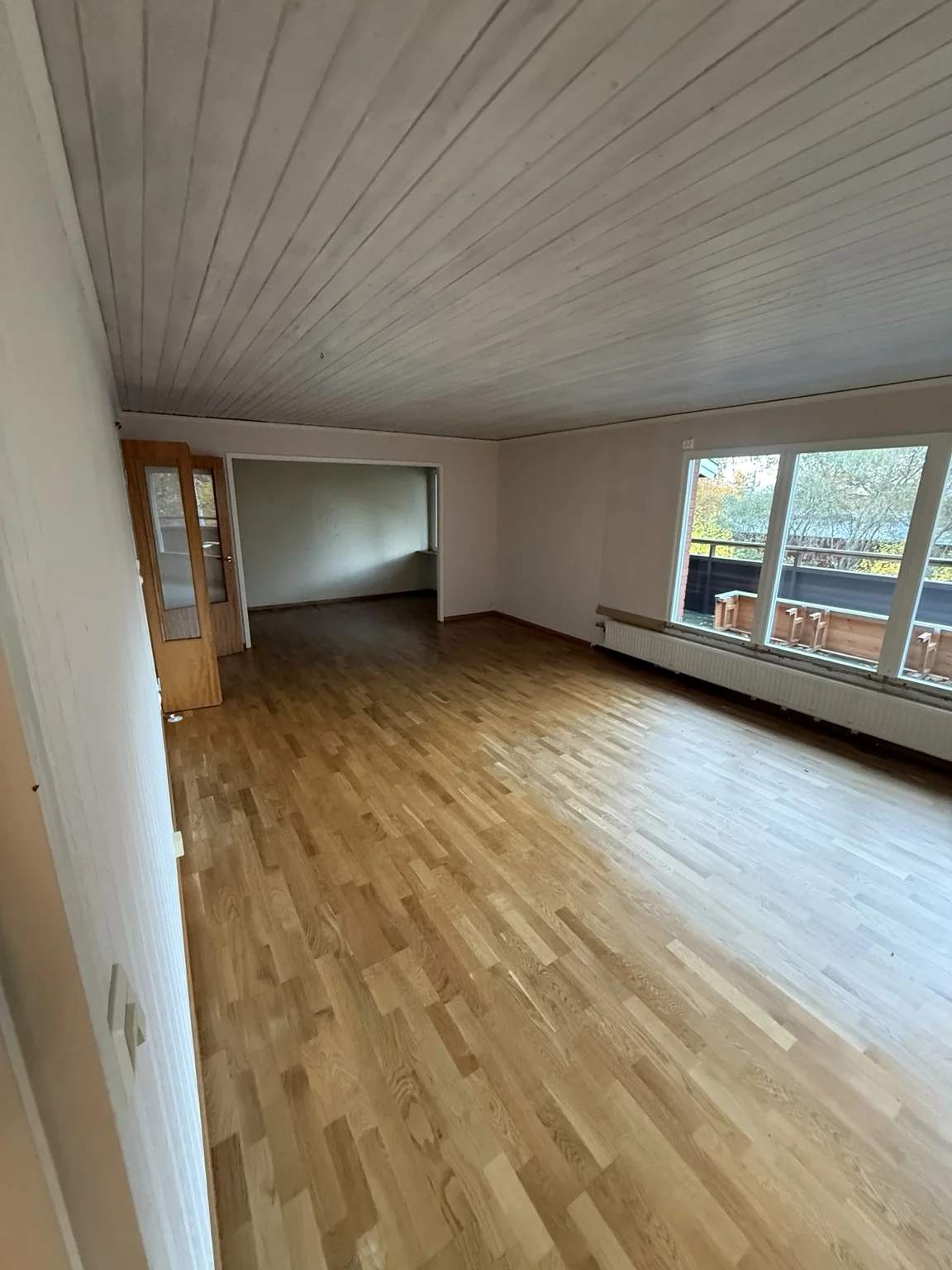 Vardagsrum med parkett och stora fönster före renoveringen, övervåningen i Villa Bällsta