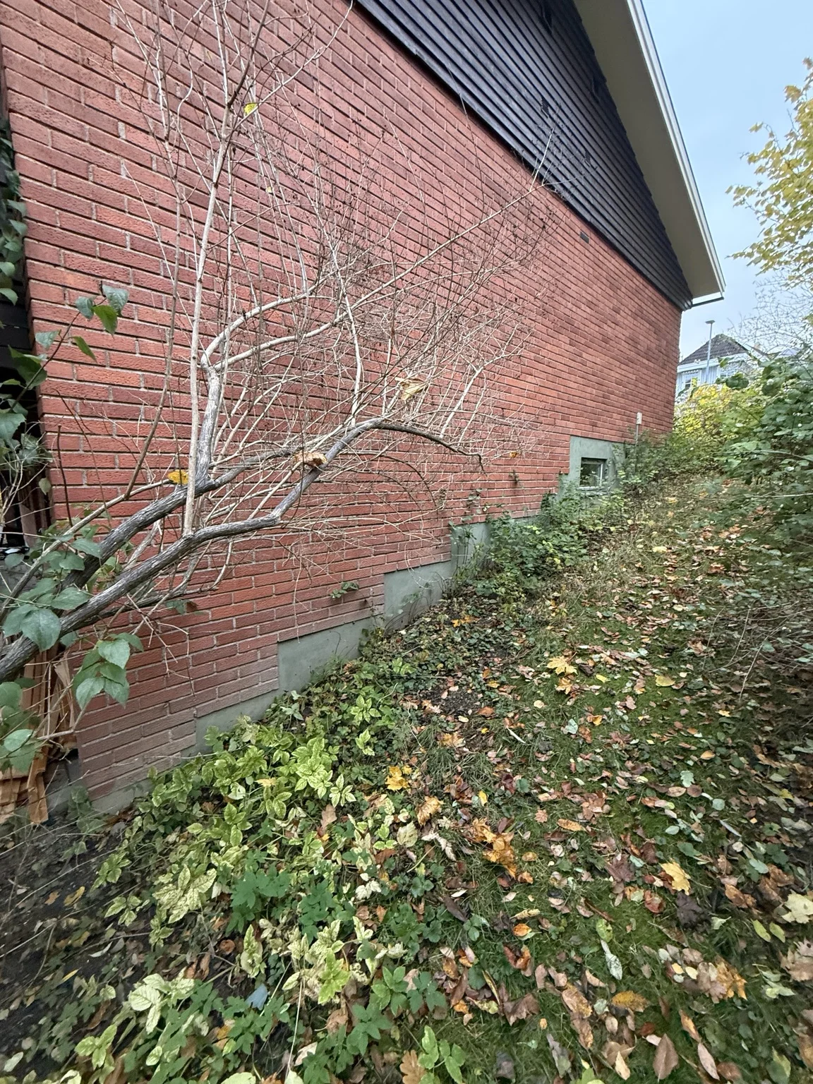 Tegelgavel och mark intill husgrunden före renoveringen av Villa Bällsta