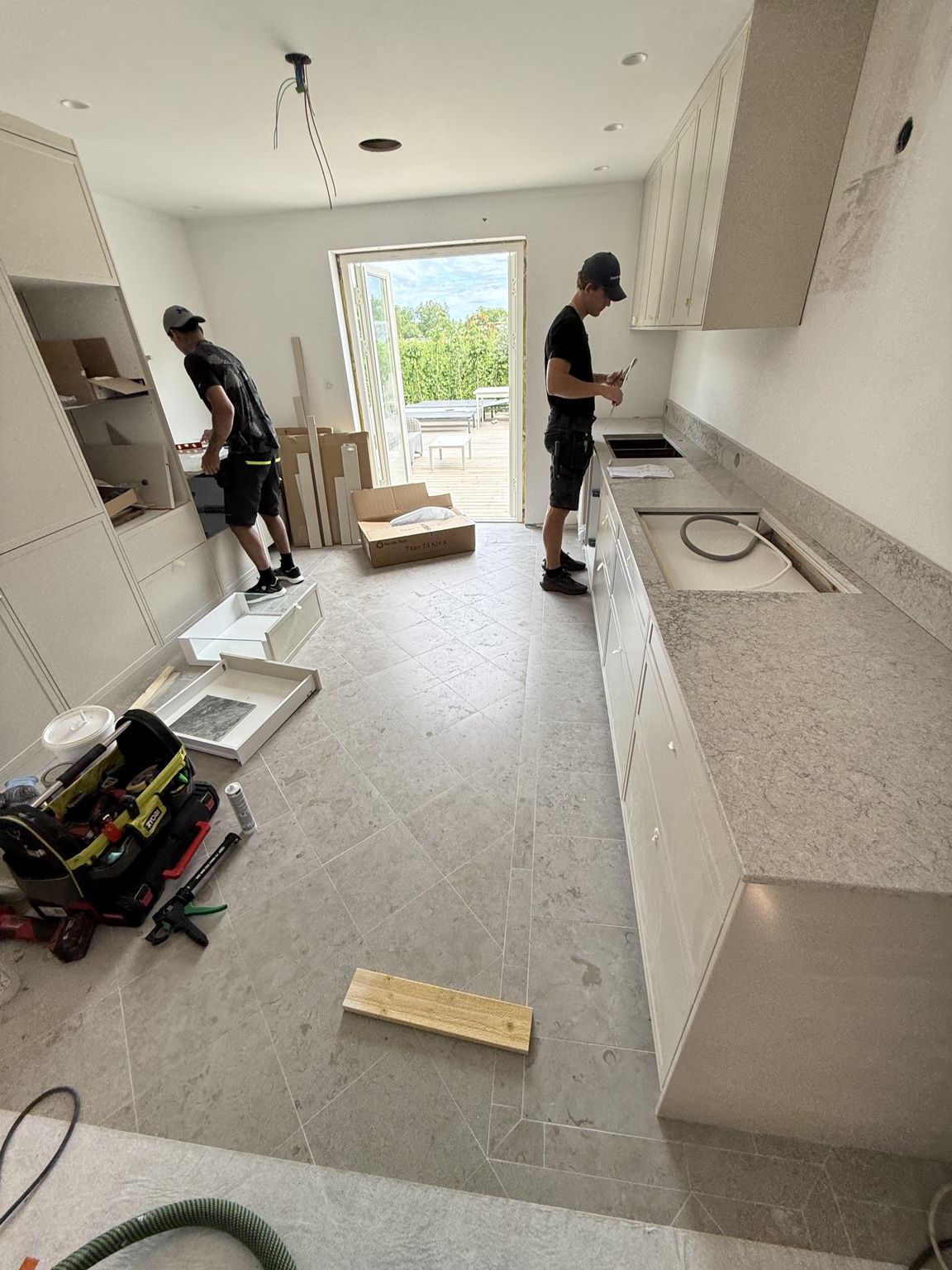 Köksmontering i Villa Stocksund med ljusa skåp och bänkskivor